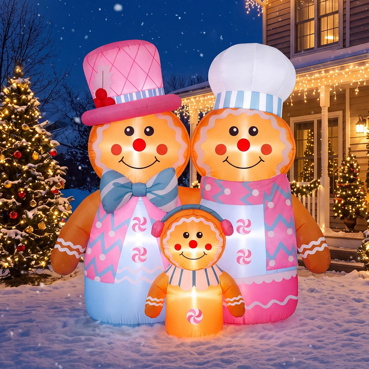 Inflatable pink gingerbread family in chef and Santa hats beside a Christmas tree